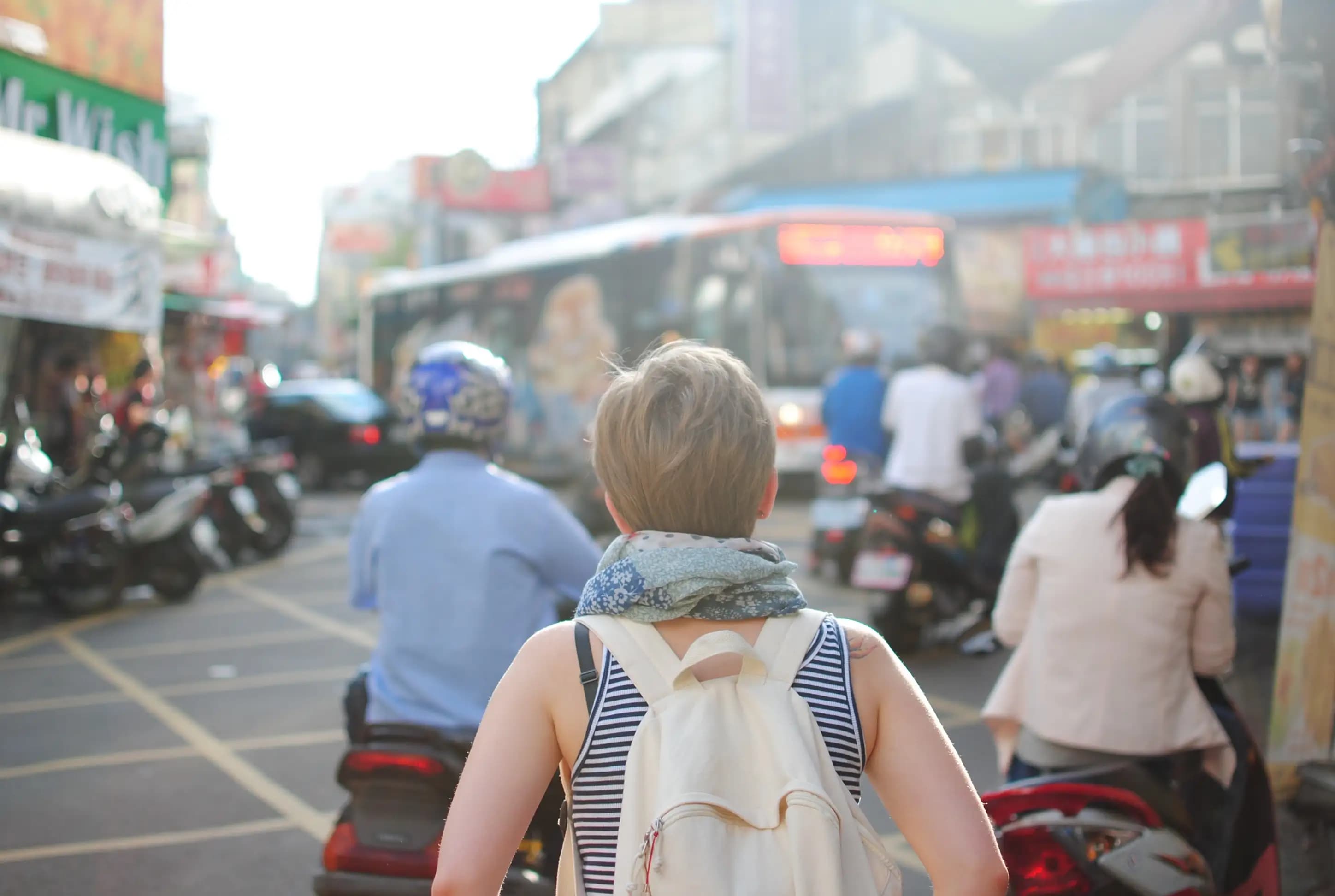 Woman with backpack walk in busy street