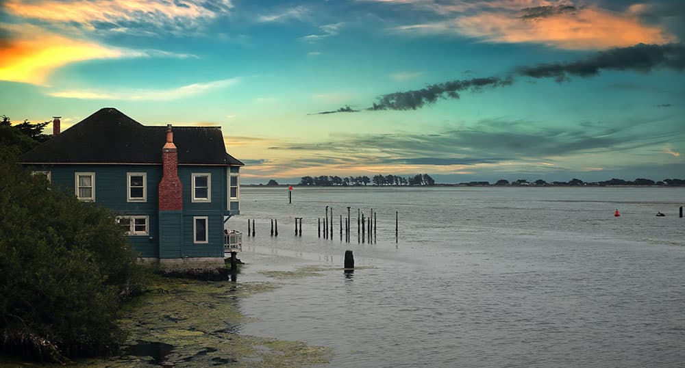 Beach house sitting right on the water at sunset