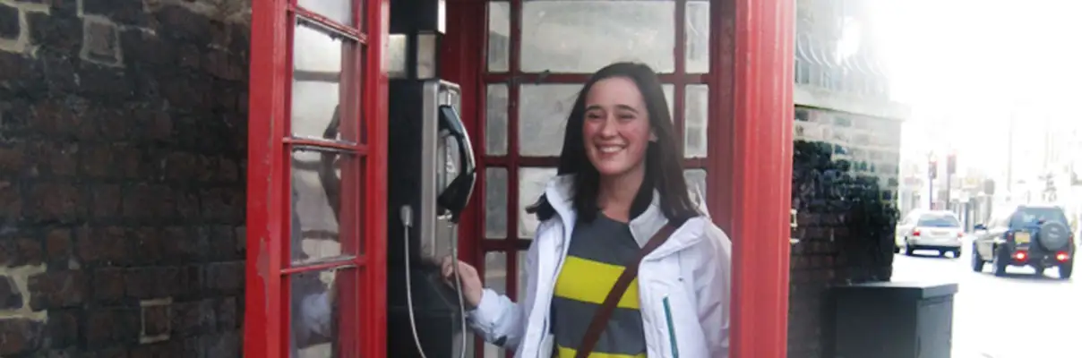 Author stands in a red phone booth in London