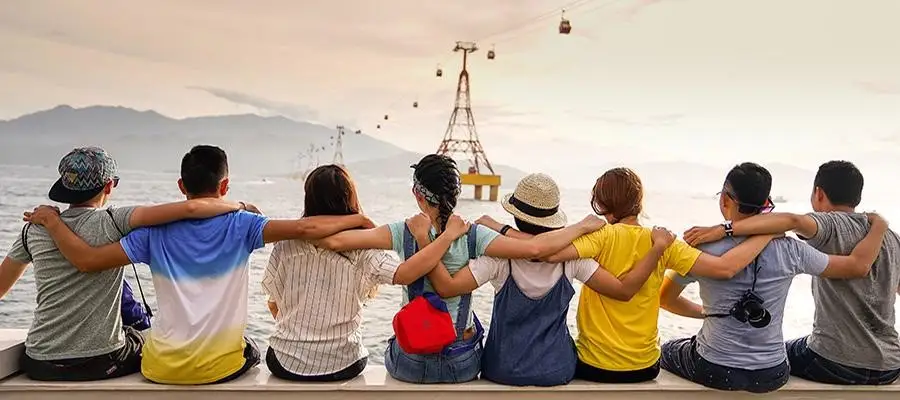 Group of students sit with their arms around each other's shoulders