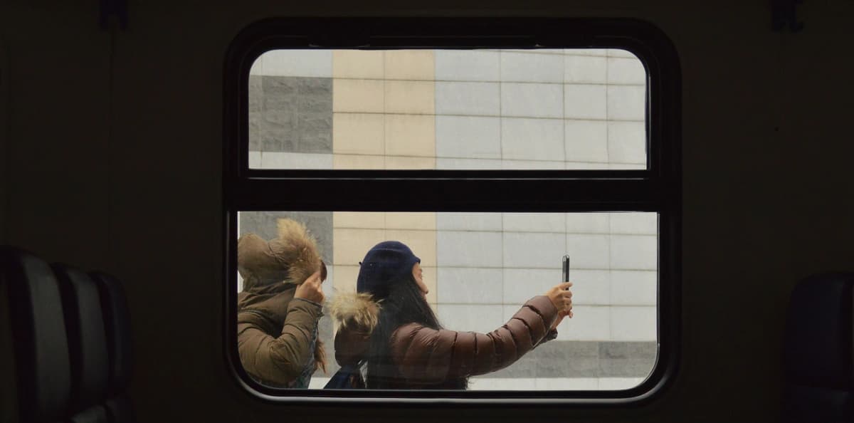 Two women take a picture with a cell phone