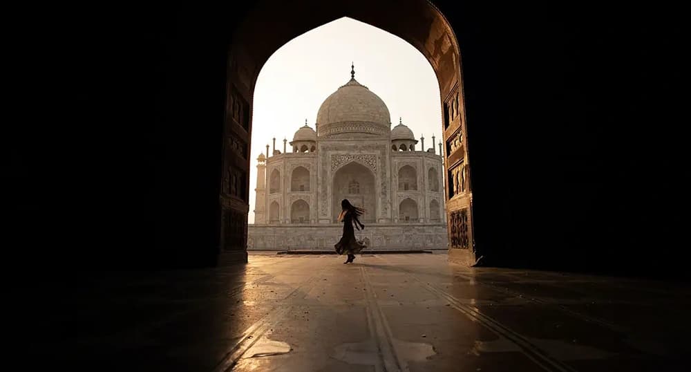 View from through a doorway of a person walking in a courtyard at Taj Mahal in India